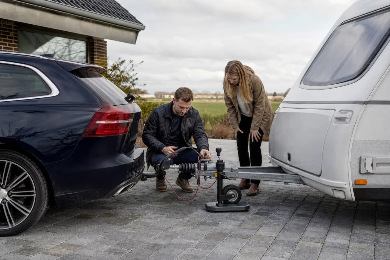 Et par kontrollerer kobling og kugletryk mellem bil og campingvogn